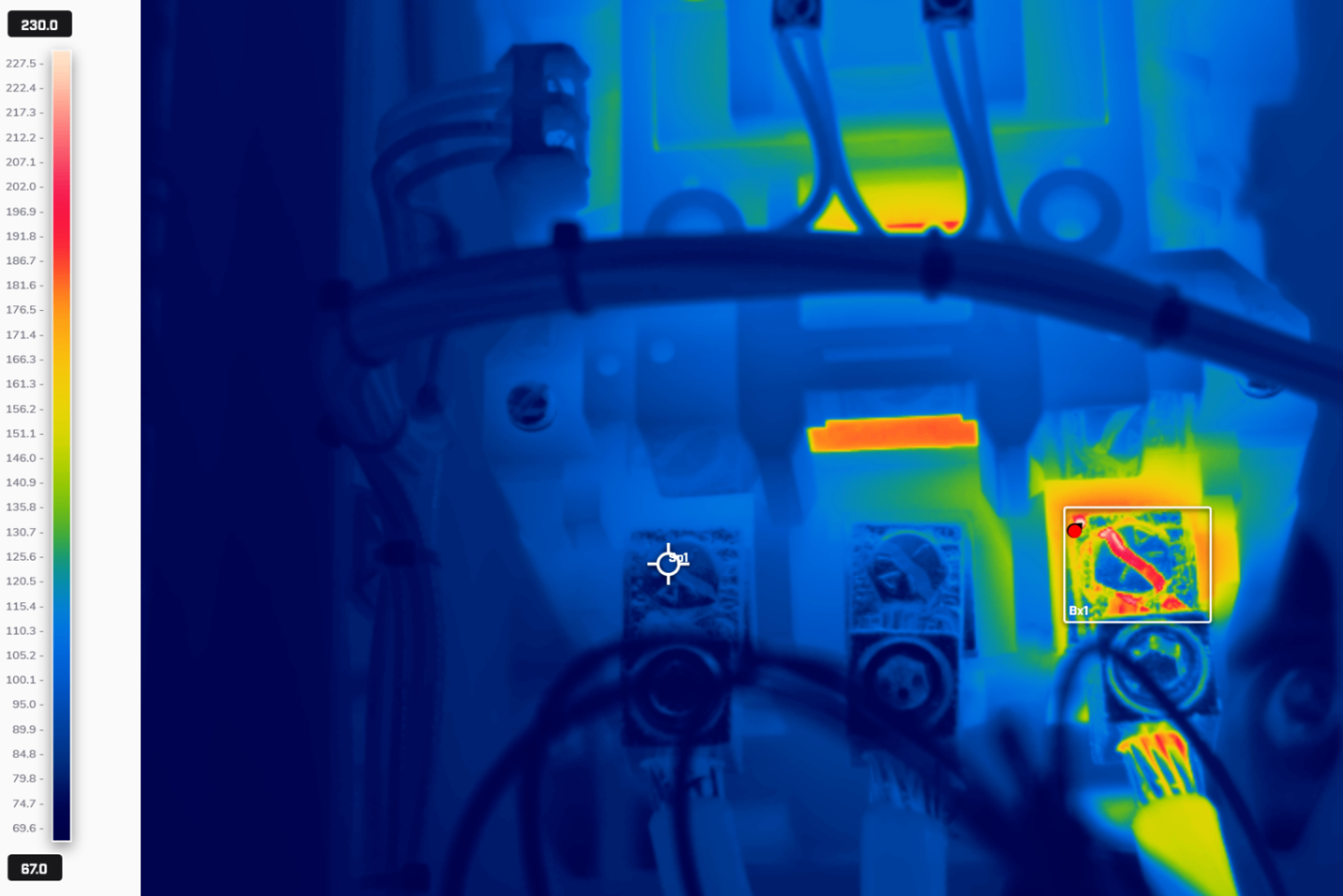 Thermographer scanning industrial equipment with infrared camera